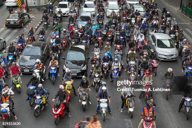 many scooters and cars on a road in bangkok - traffic jams in bangkok fotografías e imágenes de stock