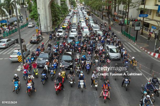 many scooters and cars on a road in bangkok - traffic jams in bangkok fotografías e imágenes de stock