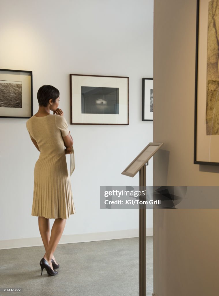 African woman enjoying photographs in museum