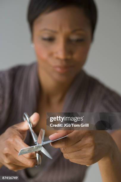 frustrated african woman cutting up credit card - debt free stock pictures, royalty-free photos & images