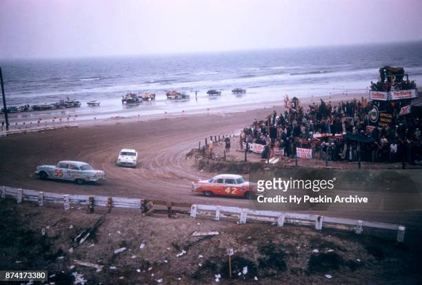 Lee Petty in the Dodge car races along the beach as Junior Johnson in the Pontiac car spins out during the Daytona Beach and Road Course on February...