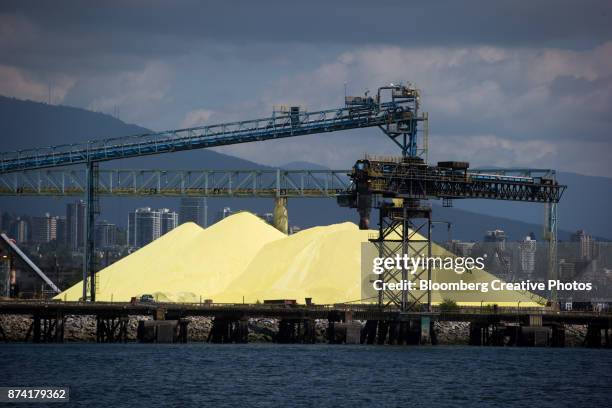 a sulfur pile is seen at a port in british columbia - schwefel stock-fotos und bilder
