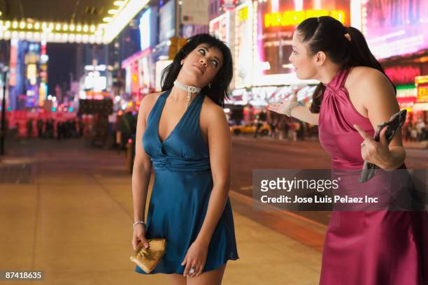 hispanic friends arguing on sidewalk at night - friends argue fotografías e imágenes de stock