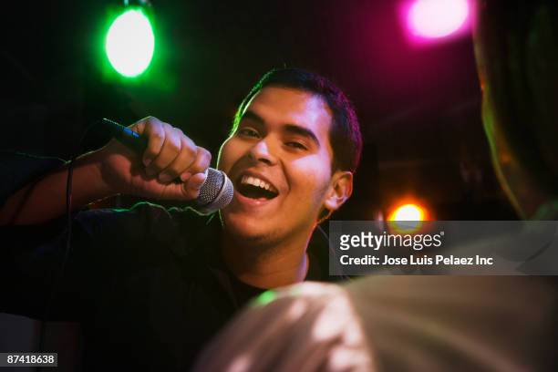 hispanic man singing in nightclub - microphone mouth stock pictures, royalty-free photos & images