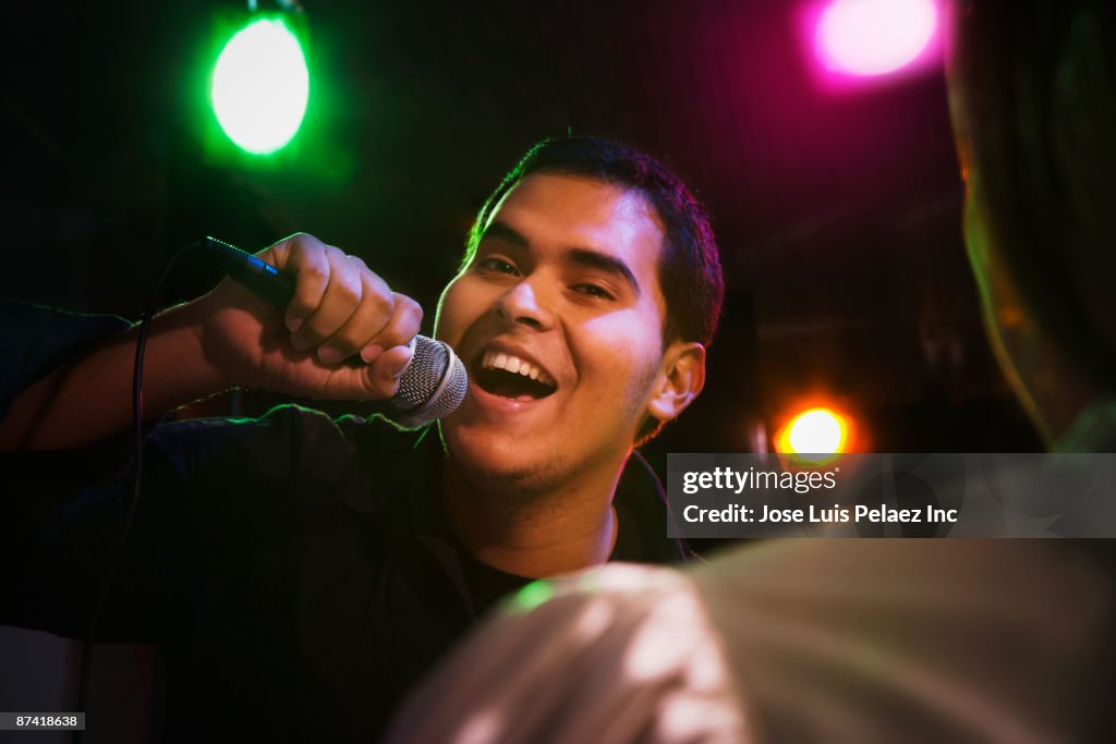 Hispanic man singing in nightclub