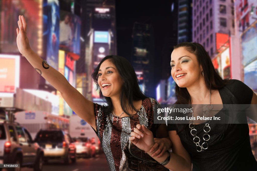 Hispanic women hailing taxi cab