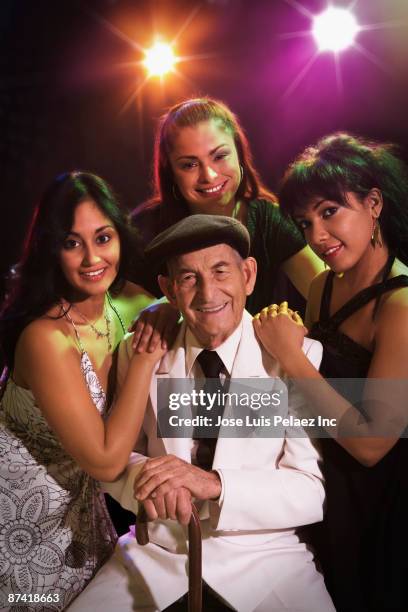 hispanic women hugging senior man in nightclub - stereotypically upper class stock pictures, royalty-free photos & images