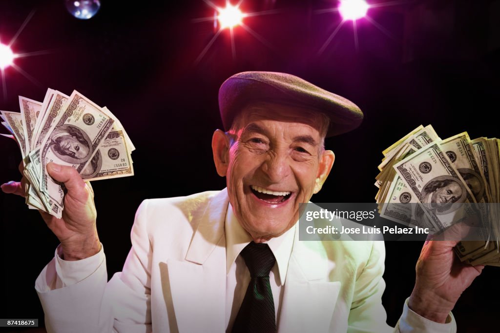 Hispanic senior man with cash in nightclub