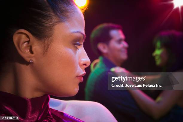 jealous hispanic woman in nightclub - envy fotografías e imágenes de stock