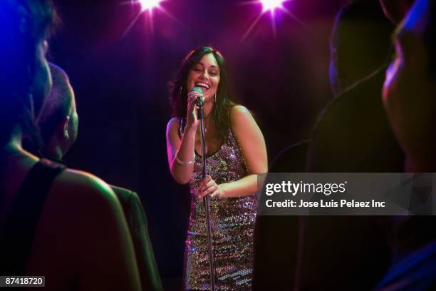 hispanic woman singing in nightclub - the weekend singer stock-fotos und bilder