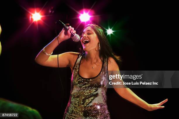 hispanic woman singing in nightclub - karaoke stock pictures, royalty-free photos & images