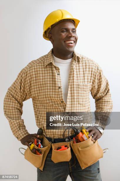 african construction worker in hard-hat and tool belt - hard hat white background ストックフォトと画像