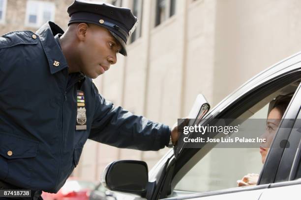 african policeman giving woman ticket - police hat stock pictures, royalty-free photos & images