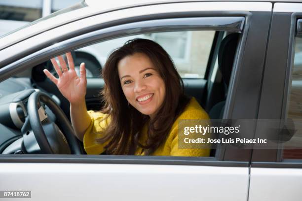 hispanic woman driving and waving - woman waving stock pictures, royalty-free photos & images