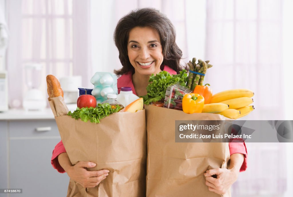 Hispanic woman carrying grocery bags