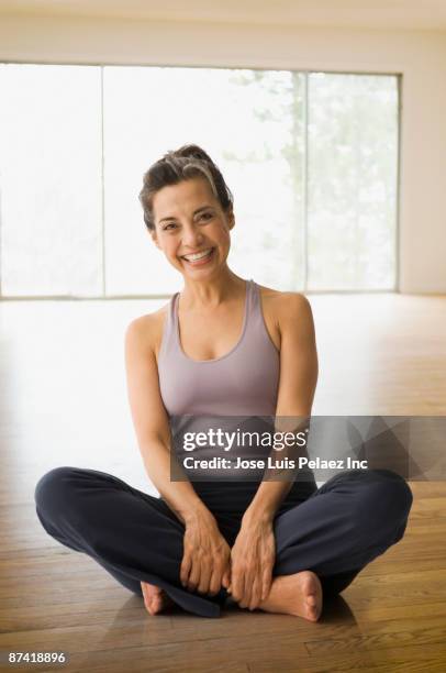 hispanic woman practicing yoga - yoga rug photos et images de collection