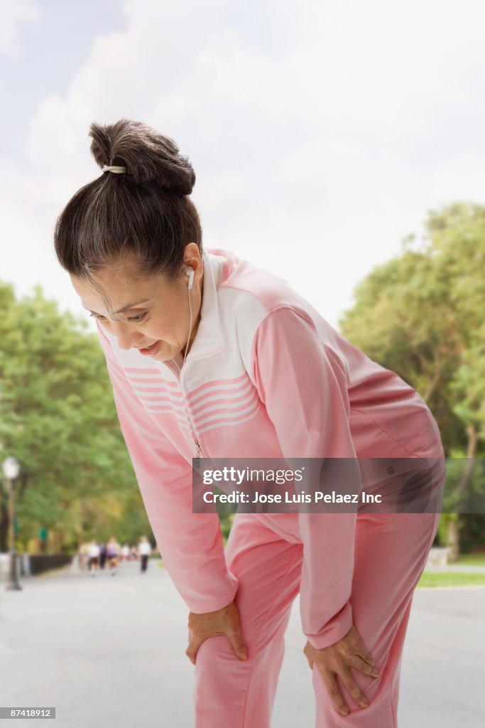 Hispanic woman with headphones resting after exercise