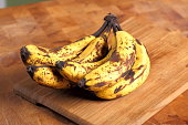 Bunch of overripe bananas on a wooden background