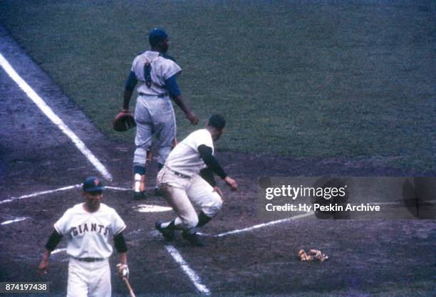 Orlando Cepeda of the San Francisco Giants scores as catcher John Roseboro of the Los Angeles Dodgers was late with the tag as Jose Pagan of the...