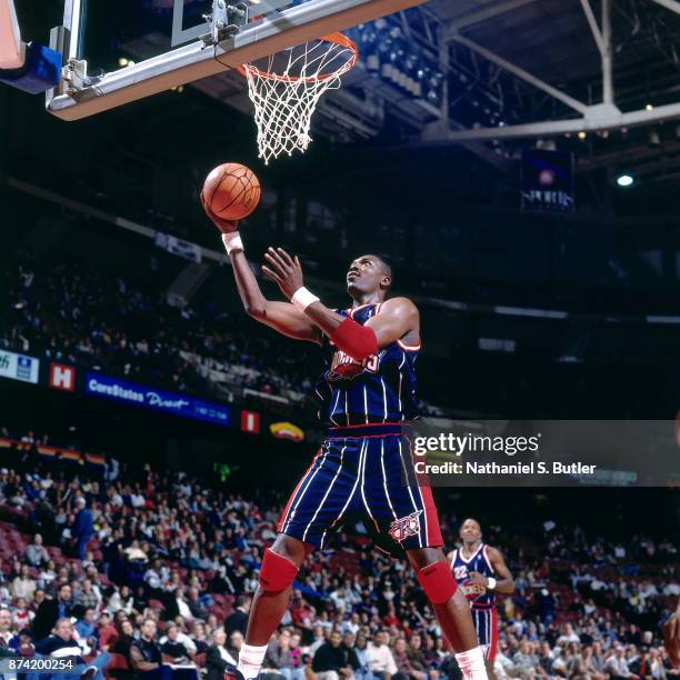 Hakeem Olajuwon of the Houston Rockets shoots during a game played on November 22, 1995 at the Spectrum in Philadelphia, Pennsylvania. NOTE TO USER:...