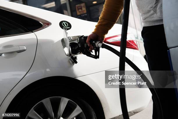 Man fills his car up with gas at a station on November 14, 2017 in New York City. According to a new report by the International Energy Agency,...
