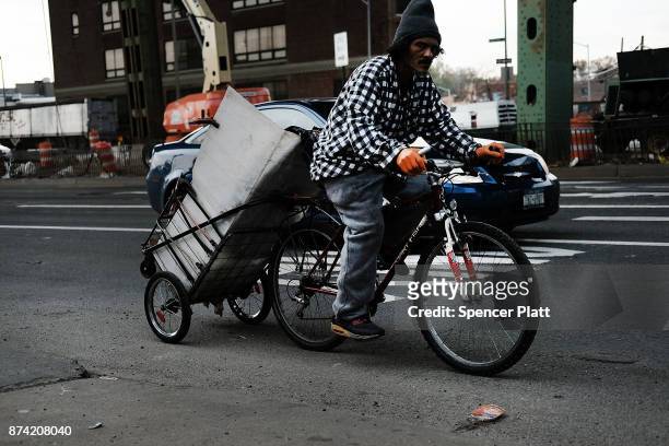 Man rides a bicycle along a busy road on November 14, 2017 in New York City. According to a new report by the International Energy Agency, global oil...