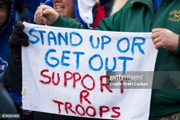 Fans wave a hand painted sign encouraging players to stand for the national anthem during the game between the Buffalo Bills and the New Orleans...