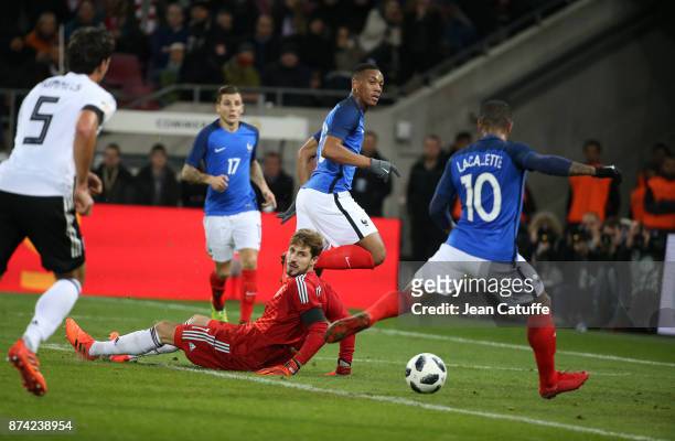 Alexandre Lacazette of France scores the first goal for France with an assist from Anthony Martial while goalkeeper of Germany Kevin Trapp looks on...