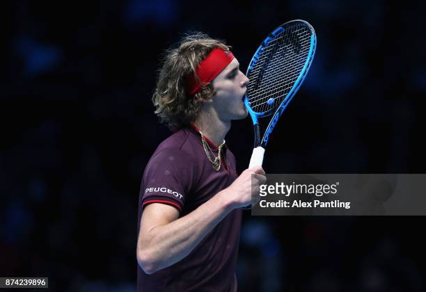 Alexander Zverev of Germany bites his racket in frustraion during the singles match against Roger Federer of Switzerland on day three of the Nitto...