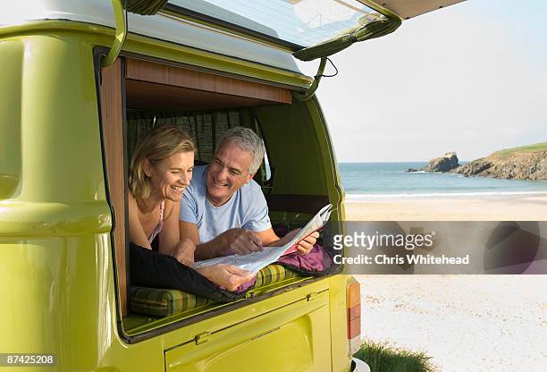 mature couple lying in camper van - 50 59 years stock pictures, royalty-free photos & images