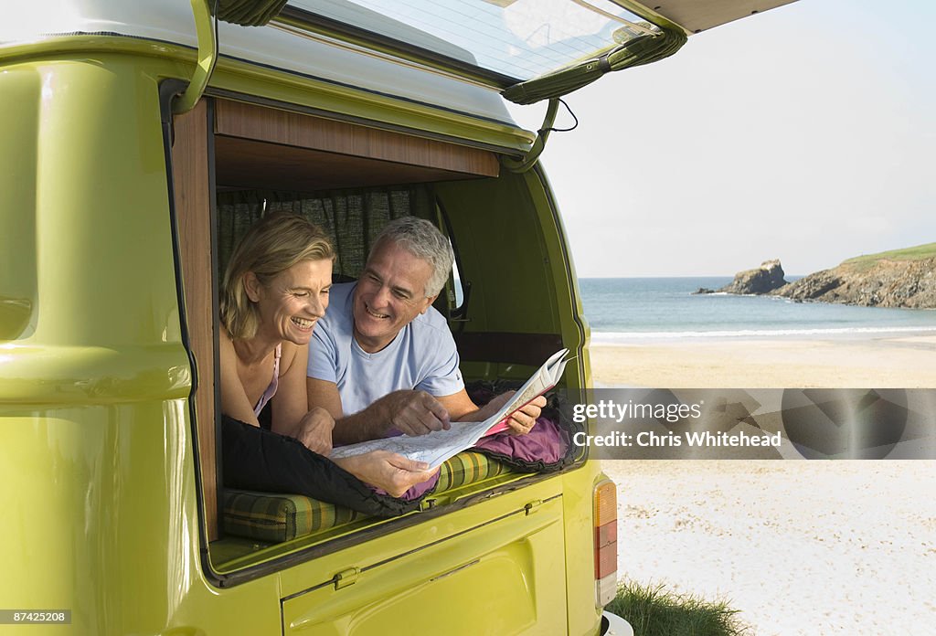 Mature couple lying in camper van