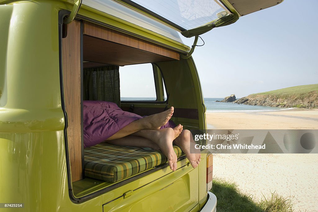 Couple lying in camper van
