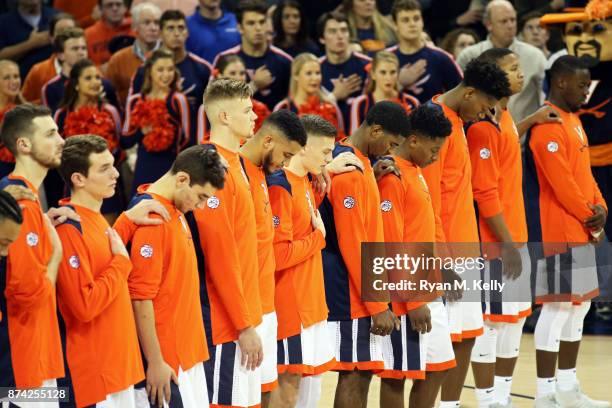 Virginia Cavaliers players stand for the national anthem before the start of a game against the Austin Peay Governors at John Paul Jones Arena on...