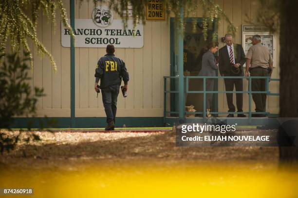 Agents are seen behind yellow crime scene tape outside Rancho Tehama Elementary School after a shooting in the morning on November 14 in Rancho...