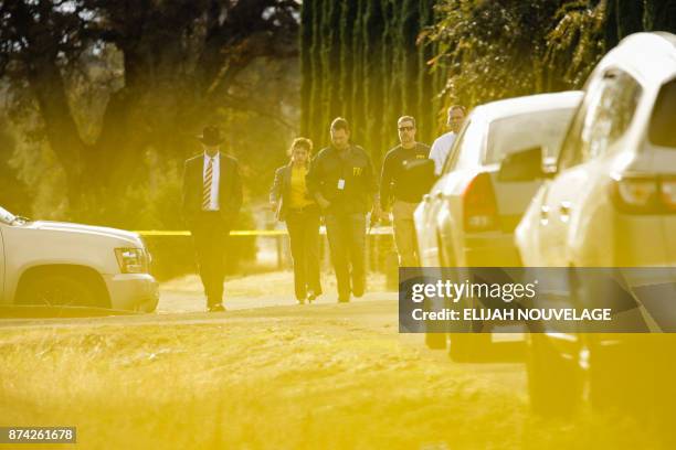 Agents are seen behind yellow crime scene tape outside Rancho Tehama Elementary School after a shooting in the morning on November 14 in Rancho...