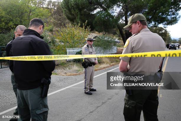 Law enforcement officers stand near one of many crime scenes after a shooting on November 14 in Rancho Tehama, California. Four people were killed...