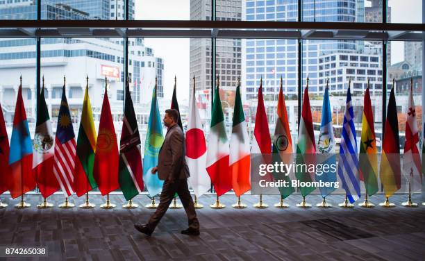 An attendee walks by flags of participating United Nation countries during the 2017 UN Peacekeeping Defence Ministerial conference in Vancouver,...