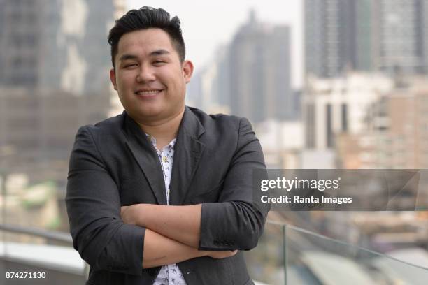 jonge knappe aziatische zakenman genieten van het leven in de stad van bangkok, thailand - fat asian man stockfoto's en -beelden