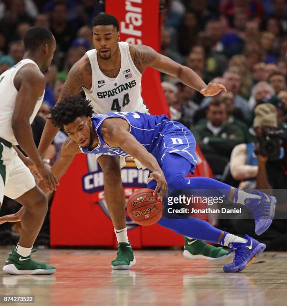 Marvin Bagley III of the Duke Blue Devils tries to control the ball under pressure from Nick Ward of the Michigan State Spartans during the State...