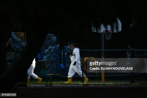 People in white protective suits are seen on the Rancho Tehama Elementary school grounds after a shooting on November 14 in Rancho Tehama,...