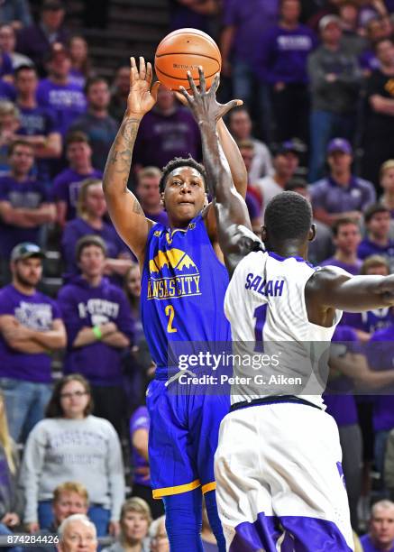 Guard Isaiah Ross of the Missouri-Kansas City Kangaroos shoots and scores over forward Mawdo Sallah of the Kansas State Wildcats during the first...