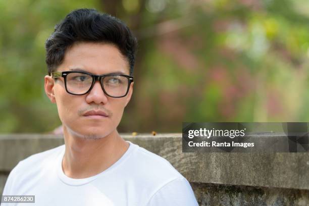 jonge aziatische man dragen smart casual kleding in de straten buiten - bril met hoornen montuur stockfoto's en -beelden