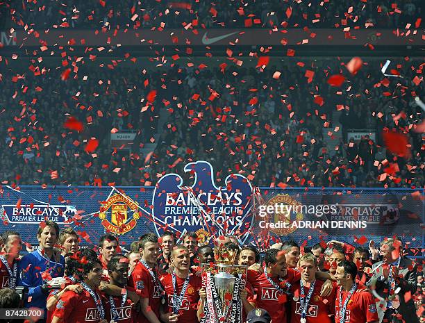 Manchester United players celebrate after winning the English Premier League after clinching the title with a 0-0 draw against Arsenal in the English...