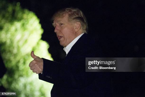 President Donald Trump gives a thumbs up while walks towards the White House on the South Lawn after returning from an 11-day Asia trip in...