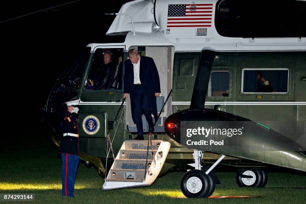 President Donald Trump walks off Marine One on the South Lawn of the White House after returning from an 11-day Asia trip November 14, 2017 in...