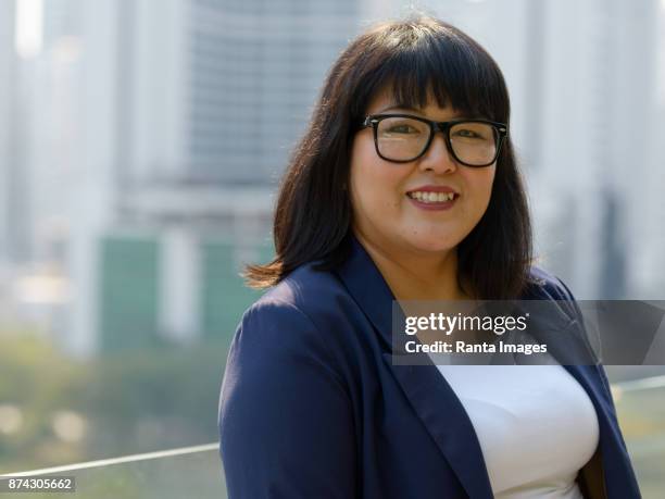 beautiful overweight asian businesswoman against view of the city in bangkok, thailand - short hair for fat women stock pictures, royalty-free photos & images