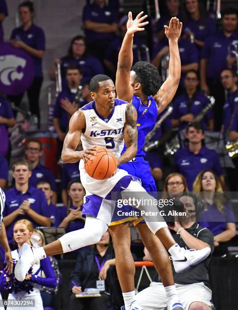Guard Barry Brown of the Kansas State Wildcats drives to the basket against guard Broderick Robinson of the Missouri-Kansas City Kangaroos during the...