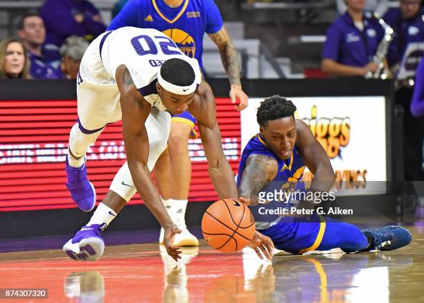 Forward Xavier Sneed of the Kansas State Wildcats scrambles for a loose ball against guard Isaiah Ross of the Missouri-Kansas City Kangaroos during...