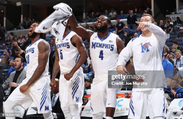 Mike Parks Jr. #10, Raynere Thornton and Alex Moffatt of the Memphis Tigers celebrate from the bench against the Little Rock Trojans on November 14,...