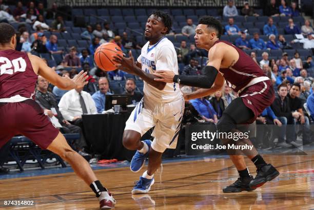 Malik Rhodes of the Memphis Tigers drives with the ball against Jaizec Lottie and K.J. Gilmore of the Little Rock Trojans on November 14, 2017 at...